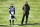 Jockey Rachael Blackmore, left, stands in the parade ring during the two minute silence before the first race on the third day of the Grand National Horse Racing meeting at Aintree racecourse, near Liverpool, England, Saturday April 10, 2021. (Peter Powell/Pool via AP)