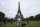 People relax at the Champ-de-Mars garden next to the Eiffel Tower in Paris, Friday, July 16, 2021. The Eiffel Tower is reopening Friday for the first time in nine months, just as France faces new virus rules aimed at taming the fast-spreading delta variant. The