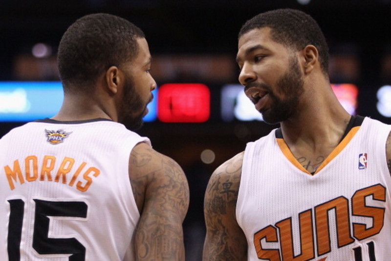 Phoenix Suns' Marcus Morris (15) and his twin brother Markieff Morris (11)  take the court during a time out during the second half of an NBA  basketball game against the Utah Jazz