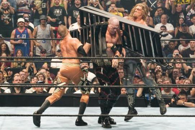 Edge e Christian collaborano per mettere al tappeto Kane utilizzando delle scale (Foto: Bleacher Report)