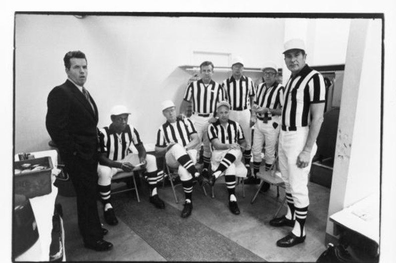 Art McNally stands with an official prior to the game between the