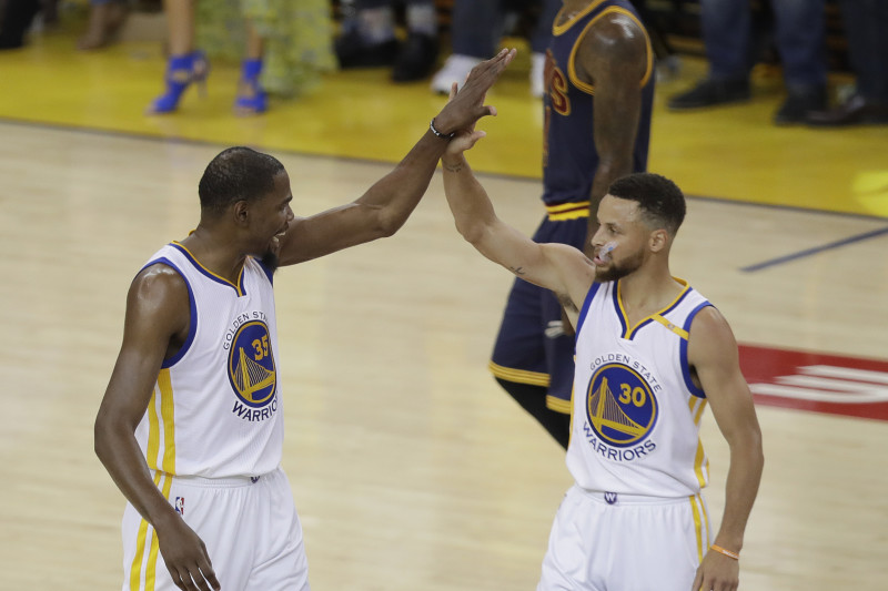 Golden State Warriors forward Kevin Durant (35) and guard Stephen Curry (30) react during the first half of Game 1 of basketball's NBA Finals against the Cleveland Cavaliers in Oakland, Calif., Thursday, June 1, 2017. (AP Photo/Marcio Jose Sanchez)