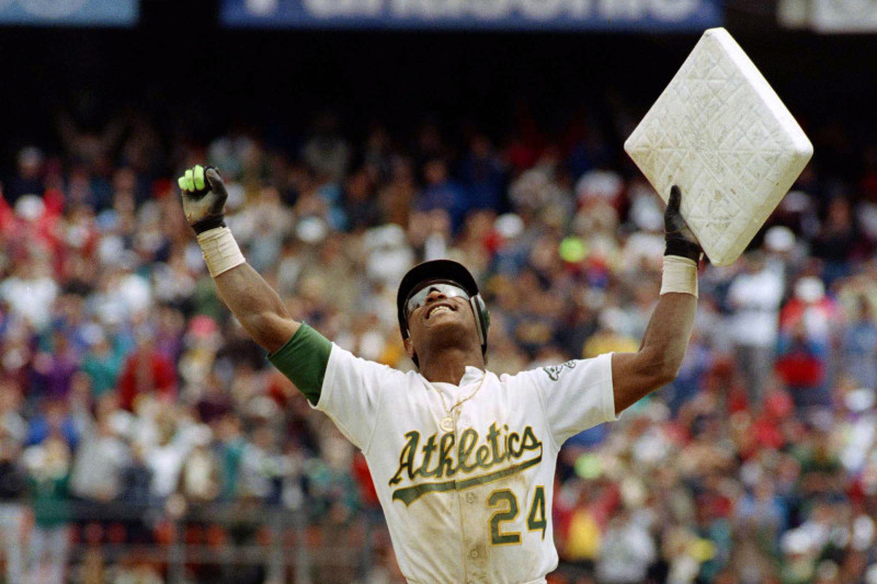 ** FILE ** In this May 1, 1991, file photo, Oakland Athletics' Rickey Henderson celebrates and raises third base after setting the all-time stolen base record during the Athletics' baseball game in Oakland, Calif., against the New York Yankees. The stolen base was Henderson's 939th, moving him past Lou Brock. Henderson was voted into baseball's Hall of Fame on Monday, Jan. 12, 2009. (AP Photo/Eric Risberg, File)